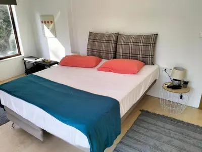a bedroom with a bed with two red pillows at Green Heaven in Koskinou
