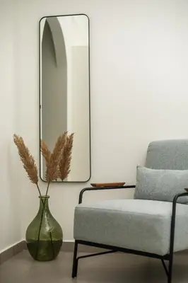 a living room with a vase and a mirror at Nόka Suite Apartments in Faliraki