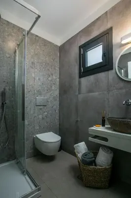 a bathroom with a shower and a toilet and a sink at Nόka Suite Apartments in Faliraki