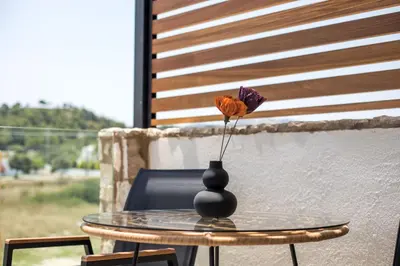 a vase with a flower sitting on a table at Nόka Suite Apartments in Faliraki