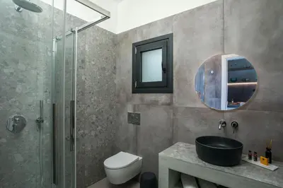 a bathroom with a shower and a toilet and a sink at Nόka Suite Apartments in Faliraki