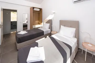 a hotel room with two beds and a sink at Euphoria Blue Villa στην περιοχή Ιξιά in Rhodes Town