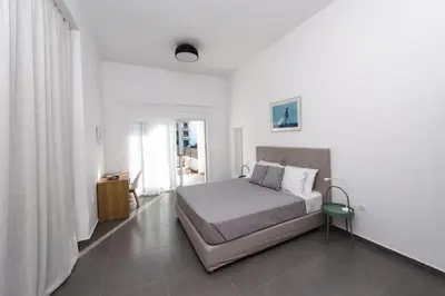 a white bedroom with a bed and a window at Euphoria Blue Villa στην περιοχή Ιξιά in Rhodes Town