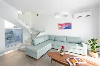 a living room with a couch and a table at Euphoria Blue Villa στην περιοχή Ιξιά in Rhodes Town