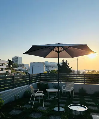 a table and chairs under an umbrella on a roof at Euphoria Blue Villa στην περιοχή Ιξιά in Rhodes Town