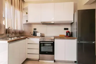 a kitchen with white cabinets and a black refrigerator at Seascape House in Kremasti