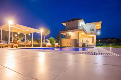 a pool in front of a building at night at Villa Cervus Dianae in Kallithea Rhodes