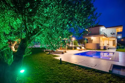 a house with a tree and a swimming pool at night at Villa Cervus Dianae in Kallithea Rhodes