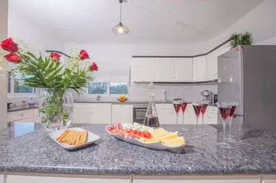 a kitchen with a counter with cheese and wine glasses at Villa Cervus Dianae in Kallithea Rhodes