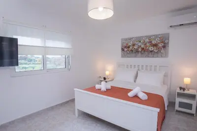 a white bedroom with a bed and a window at Villa Cervus Dianae in Kallithea Rhodes