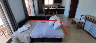 a bedroom with a white bed with two red arrows at el greco apartment in Rhodes Town