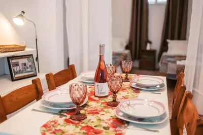 a bottle of wine sitting on a table with plates and glasses at Olympia's Cozy Guesthouse in Psinthos