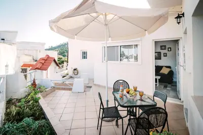 a patio with a table and chairs and an umbrella at Olympia's Cozy Guesthouse in Psinthos