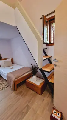 a bedroom with a bed and a stair case at Seva Monolithos house in Monólithos