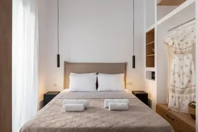 a bedroom with a large bed with two pillows at Venthos Apartments in Kolimbia