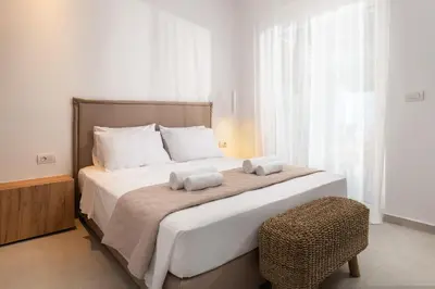 a bedroom with a large bed with two towels on it at Venthos Apartments in Kolimbia