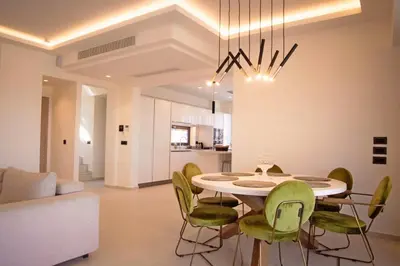 a dining room with a table and green chairs at Gatsby Rhodes -Two Brand New Exclusive Villas in Asgourou