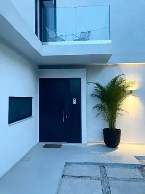 a house with a black door and a potted plant at Gatsby Rhodes -Two Brand New Exclusive Villas in Asgourou