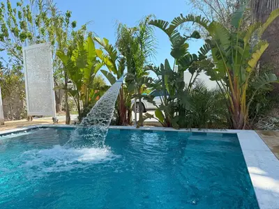 a swimming pool with a fountain in the middle at Gatsby Rhodes -Two Brand New Exclusive Villas in Asgourou