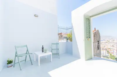 a white room with a table and chairs and a window at LA CASA DI MARCONI in Symi