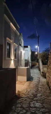 a street at night with a house and a street light at LA CASA DI MARCONI in Symi