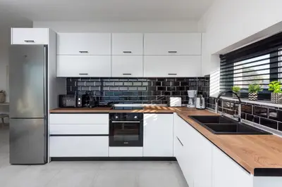 a kitchen with white cabinets and a wooden counter top at Aquarama Pool Apartments in Ixia