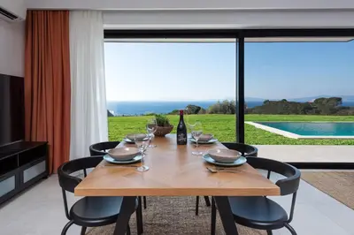 a wooden table with wine glasses and a bottle of wine at Aquarama Pool Apartments in Ixia