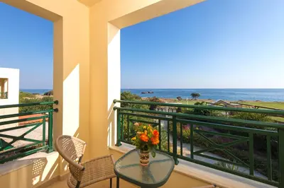 a balcony with a table and a view of the ocean at THERETRA KIOTARI VILLAS in Gennadi