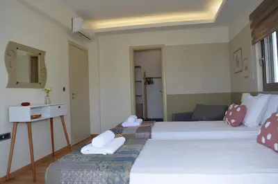 two beds in a hotel room with towels at Home21 in Asgourou