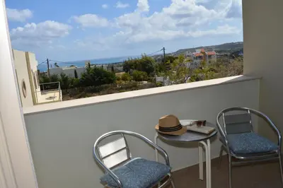 a balcony with a table and two chairs and a window at Home21 in Asgourou