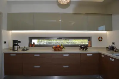 a kitchen with brown cabinets and a bowl of fruit at Home21 in Asgourou