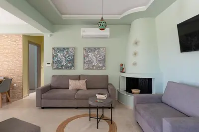 a living room with two couches and a fireplace at Ethria Pool Villa with heated jacuzzi in Afantou