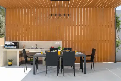 a patio with a table and chairs and a kitchen at Ethria Pool Villa with heated jacuzzi in Afantou