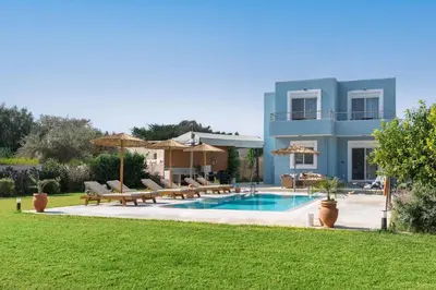 a villa with a swimming pool in front of a house at Ethria Pool Villa with heated jacuzzi in Afantou