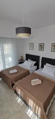two beds in a hotel room with two mattresses at Giotouli Apartment in Afantou