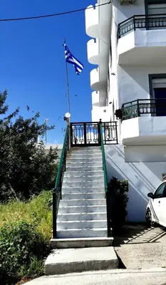 a stairway leading up to a building with an american flag at Giotouli Apartment in Afantou