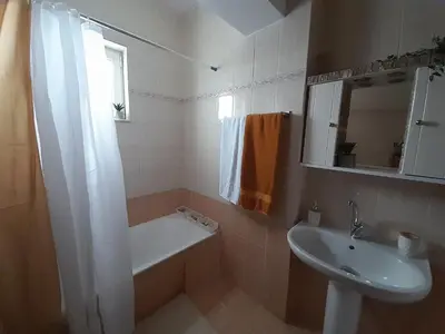 a bathroom with a sink and a bath tub and a sink at Giotouli Apartment in Afantou