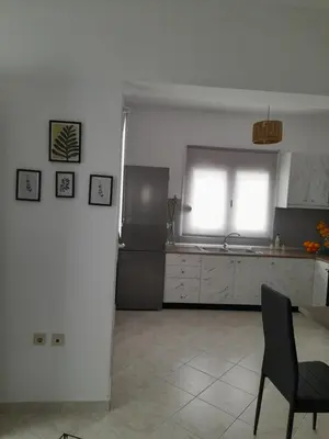 a kitchen with a refrigerator and a table and a window at Giotouli Apartment in Afantou