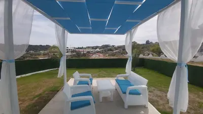 a table and chairs on a patio with a blue ceiling at GR House Eleftheria in Afantou