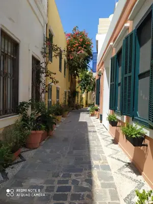 an alley in an old town with plants and buildings at Tête à Tête - Luxury Apartment in Rhodes Town
