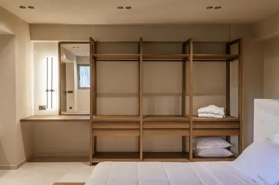 a bedroom with a book shelf and a mirror at Sevasti Seaview Suite in Koskinou