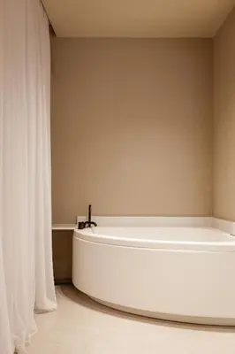 a white bath tub in a room with white curtains at Sevasti Seaview Suite in Koskinou