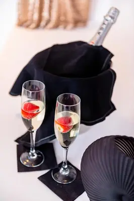 two glasses of wine on a table with a plate at Sunwaves Beach studio I in Ialyssos