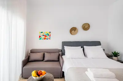 a bedroom with a bed and a couch at Sunwaves Beach studio I in Ialyssos