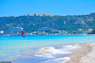a person walking in the water on a beach at Sunwaves Beach studio II in Ialyssos