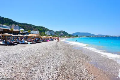 a beach with a crowd of people and the ocean at Sunwaves Beach studio II in Ialyssos