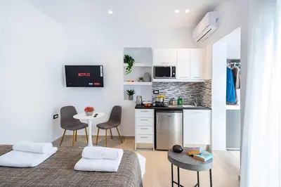 a small kitchen with two beds and a table in a room at Sunwaves Beach studio II in Ialyssos