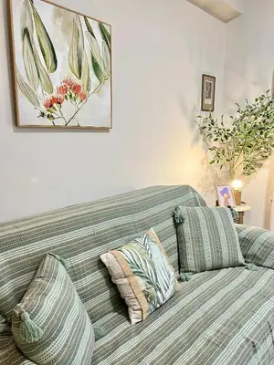 a living room with a couch and a painting on the wall at Haplotēs Rhodes Apartment in Koskinou