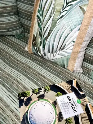 a book sitting on a couch with a clock on it at Haplotēs Rhodes Apartment in Koskinou