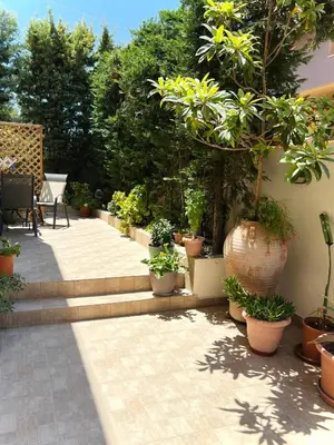 a patio with a bunch of potted plants at Haplotēs Rhodes Apartment in Koskinou
